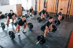 忙练习集团年轻的运动型人参考一天在室内健身房