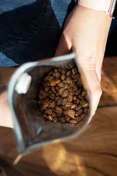烤咖啡豆打包袋咖啡师持有手前视图咖啡准备概念