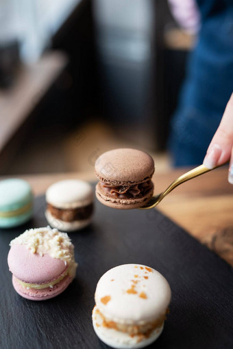 美味的macaron甜点法国甜蜜的美味谎言混凝土黑色的站女孩持有糖果叉垂直照片