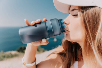 手腕女人喝水快乐活跃的中间岁的女人站海滩喝水excersise概念生活方式体育运动关闭
