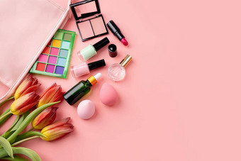 明亮的夏天眼影调色板化妆产品粉红色的化妆品袋绿色背景