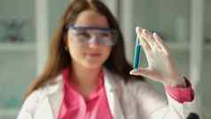 女人科学家化学家持有测试管蓝色的液体化学实验室特写镜头