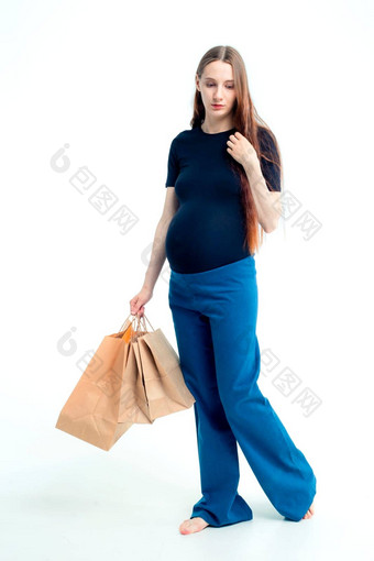 微笑美丽的年轻的怀孕了女人持有纸袋