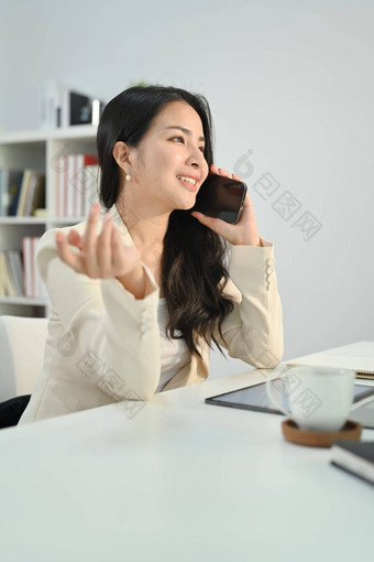 肖像微笑<strong>企业</strong>首席执行官女人坐着现代办公室会说话的移动电话