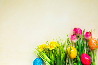 色彩斑斓的复活节鸡蛋花绿色草复活节鸡蛋消失光黄色的背景复活节假期蛋狩猎概念