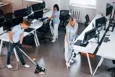 清洗地板上集团工人清洁现代办公室白天