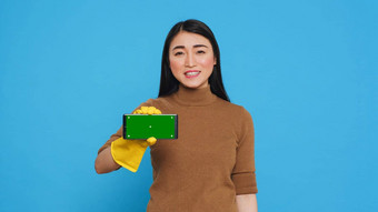 亚洲女仆持有浓度关键模拟智能手机绿色屏幕显示会说话的远程客户