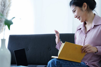 肖像自由职业者亚洲女人持有<strong>笔记本电脑</strong>视频会议<strong>首页</strong>