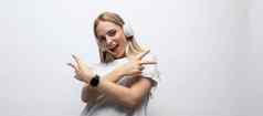 年轻的女人有趣的音乐无线耳机工作室白色墙