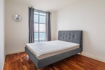 紧凑的简约舒适的双床上卧室木层压板地板白色墙灰色的窗帘窗口惊人的的观点阳光明媚的夏天一天酒店房间概念