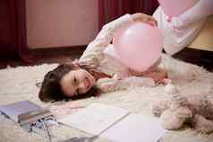 女孩睡衣说谎地毯卧室玩粉红色的柔和的气球微笑相机