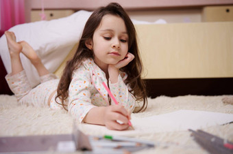 高加索人可爱的婴儿女孩时尚的睡衣画图片色彩斑斓的铅笔在室内