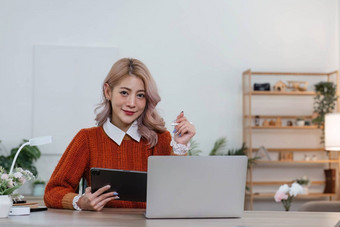 年轻的亚洲女人平板电脑微笑脸积极的情感<strong>首页</strong>休闲<strong>首页</strong>生活概念