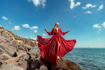 红色的衣服海女人金发女郎流动头发长流动红色的衣服站岩石海旅行概念照片会话海