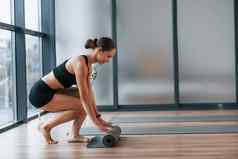 练习开始年轻的女人运动型穿苗条的身体健身瑜伽一天在室内