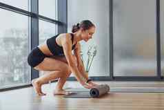 练习开始年轻的女人运动型穿苗条的身体健身瑜伽一天在室内