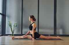 好伸展运动年轻的女人运动型穿苗条的身体健身瑜伽一天在室内