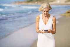 高级女人智能手机海滩夏天
