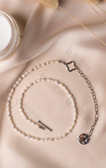 珍珠银项链丝绸背景珍珠手工制作的珠宝前视图