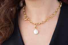 特写镜头女人穿奢侈品珍珠期间黄金项链珠宝配件概念