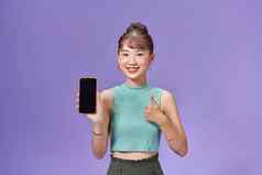 肖像微笑亚洲女人持有智能手机黑色的空白设备屏幕手显示拇指手势