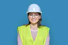 女工业建设工人需要戴安全帽的背心蓝色的背景