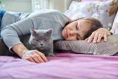 中间岁的女人睡觉猫床上