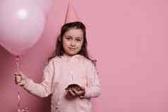 可爱的生日女孩粉红色的聚会，派对他持有群充气粉红色的气球节日蛋糕手