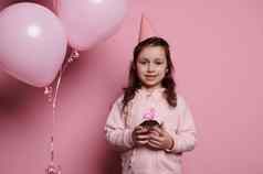 惊讶婴儿女孩粉红色的聚会，派对他持有生日蛋糕魅力基斯火烈鸟蜡烛微笑精明地相机