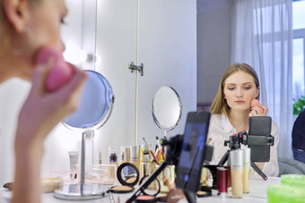 年轻的女人记录视频化妆美博客智能手机