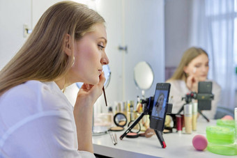 年轻的女人记录视频化妆美博客智能手机