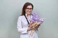 微笑成熟的女人医生护士花束花礼物庆祝活动医疗工人一天
