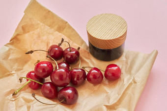 自然健康的有机化妆品水果樱桃瓶化妆品产品粉红色的背景