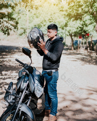年轻的骑摩托车的人男人。把安全头盔男人。摩托车把头盔骑摩托车的人把安全头盔骑摩托车的人摩托车安全概念
