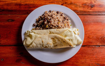 前视图传统的公鸡门quesillo服务木表格板尼加拉瓜gallopintoquesillo表格典型的尼加拉瓜食物