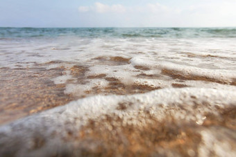 低角相机地面镜头覆盖水滴强调湿润关闭浅海波洗海滩沙子摘要海洋背景