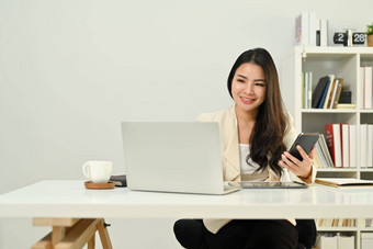微笑亚洲女销售经理移动PC电脑咨询客户端移动电话