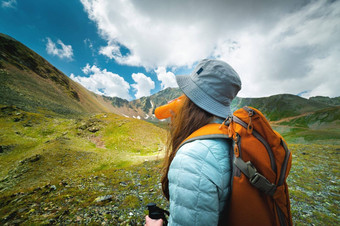 成功的旅游饮料水绿色草地高山旅行徒步旅行概念背包一边视图