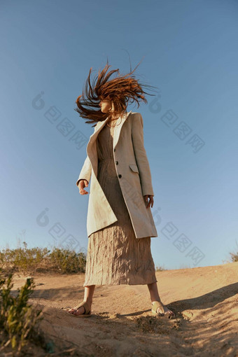 女人时尚<strong>夹克</strong>长裙子提出了站沙子背景清晰的天空覆盖脸头发<strong>运动</strong>