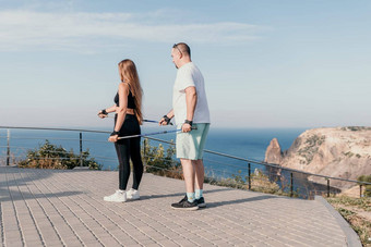 快乐中间岁的夫妇朋友练习北欧走公园海成熟的夫妇徒步旅行波兰人走练习北欧走在户外老化精神饱满地体育运动概念
