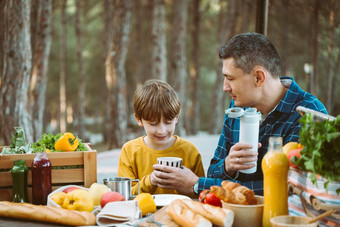 父亲爸爸学校孩子男孩孩子野餐森林野营网站蔬菜汁咖啡羊角面包木箱新鲜的有机蔬菜包围面包筷子