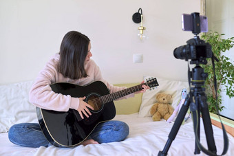 青少年女孩坐着首页床上声吉他女孩学习玩吉他在线