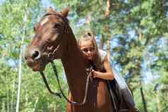 女孩孩子骑马夏天马骑森林女孩深情地拥抱马