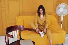 女人坐在在室内橙色彩色的房间彩色的衣服