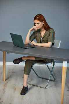 沉思的女人工作服坐在移动PC办公室工作