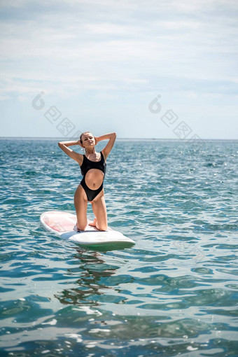 女人肉豆蔻海体育女孩冲浪板海阳光明媚的夏天一天黑色的洗澡西装坐在萨帕海休息海