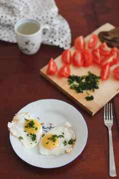 健康的食物鸡蛋板樱桃西红柿乡村木背景早餐首页