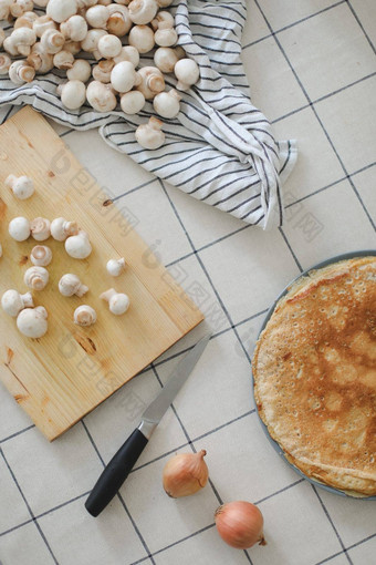 新鲜的切片食用香草蘑菇刀木董事会烹饪煎饼蘑菇白色表格前视图