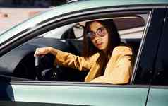 快乐汽车老板坐在内部车辆年轻的时尚女人勃艮第彩色的外套白天车