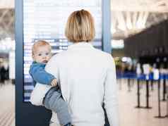 妈妈。旅行孩子持有婴儿婴儿男孩机场终端检查飞行时间表等待董事会飞机旅行孩子们概念
